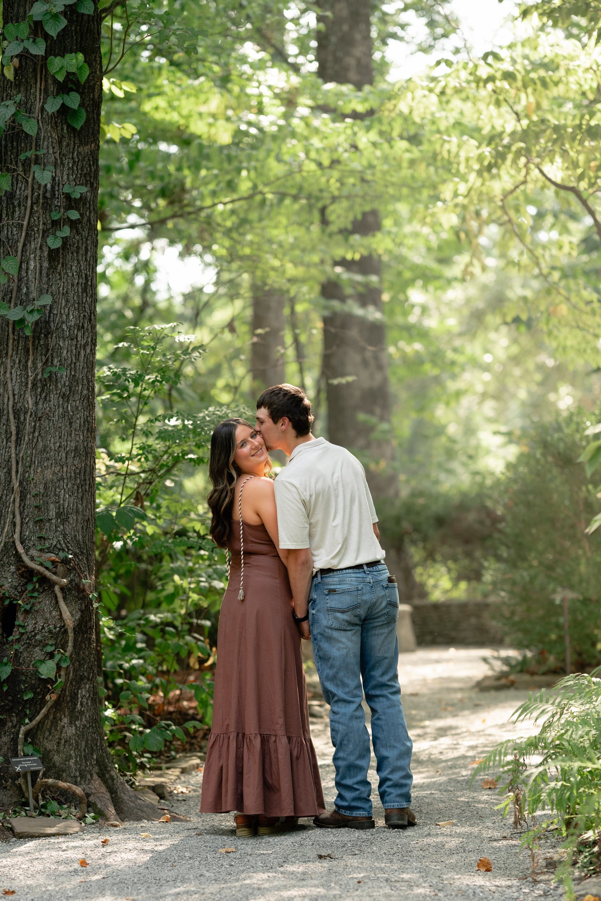 Engagement session kiss on a forest path