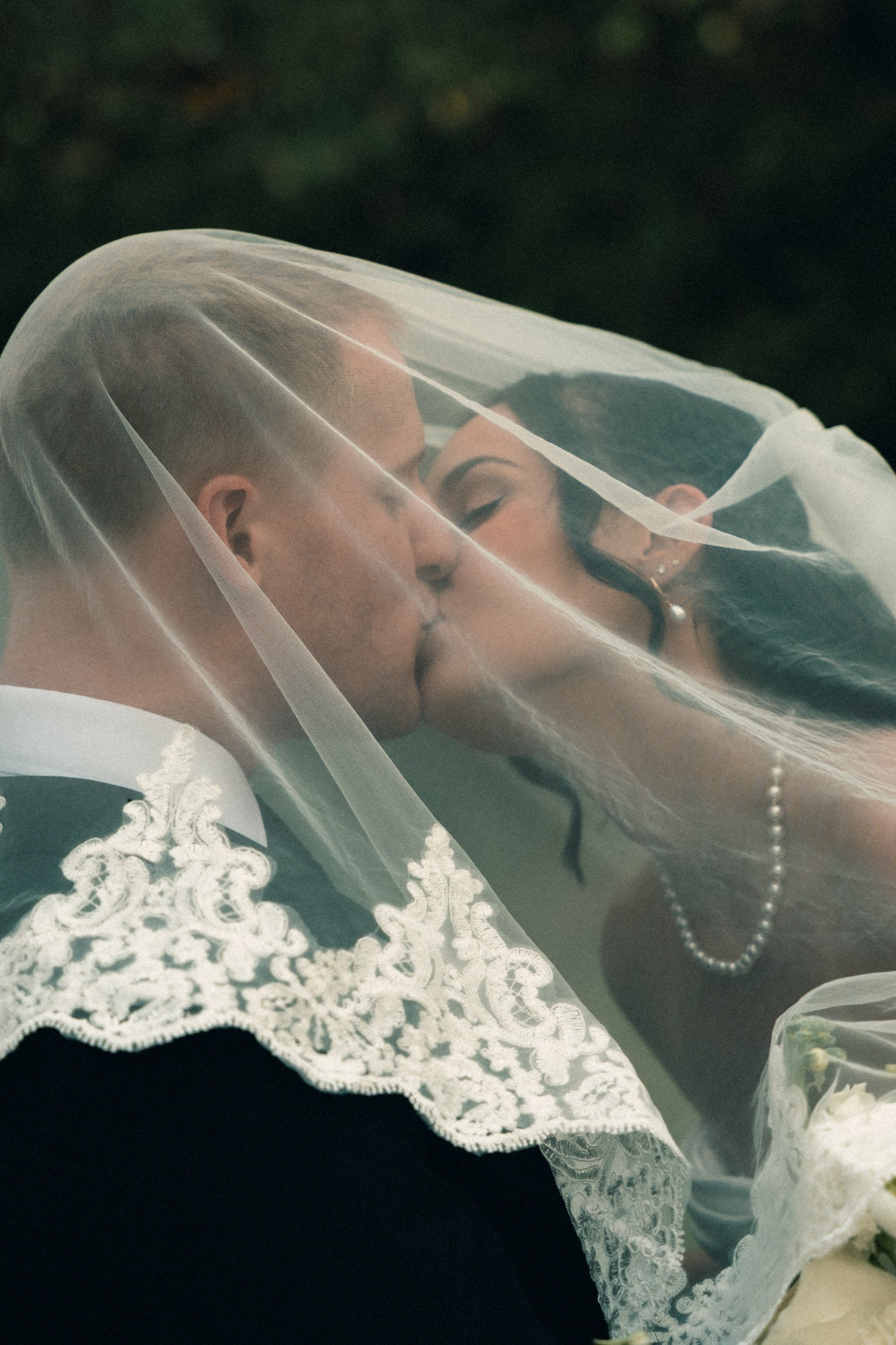 Megan and Jake sharing a kiss under the veil at Salt Chapel